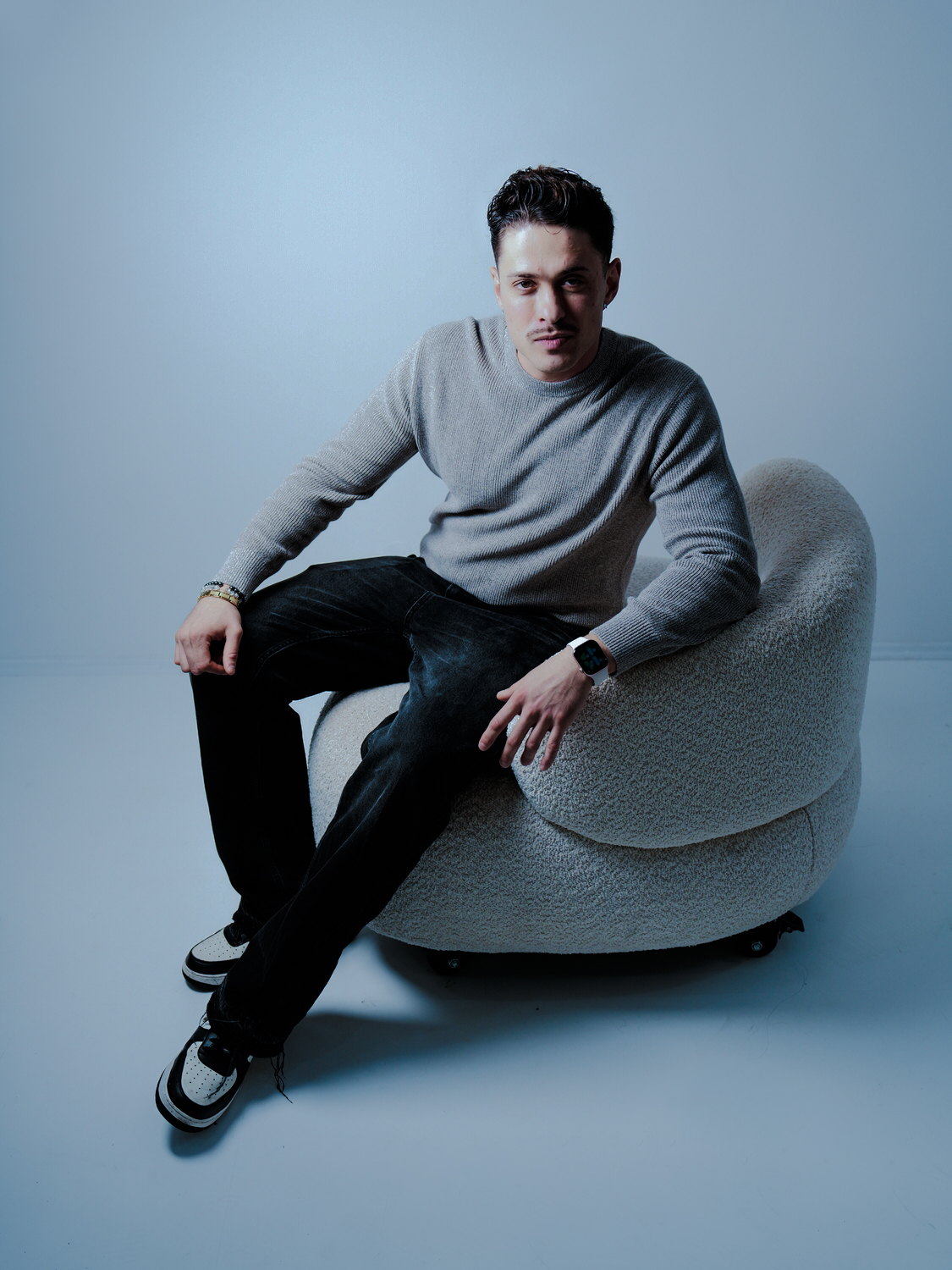 Männliches Model sitzt im Sessel während Fotoshooting, lockere Haltung, Fotograf Aachen