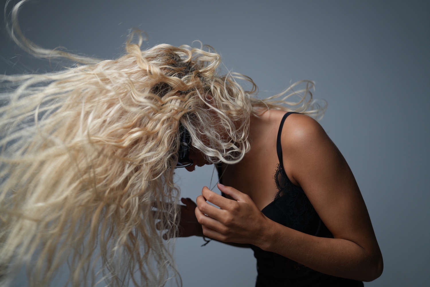 Boudoir-Fotoshooting einer Frau in Dessous, Act, Dessous, Sonnenbrille, fliegende haare, kopf nach unten geneigt,Fotograf Aachen